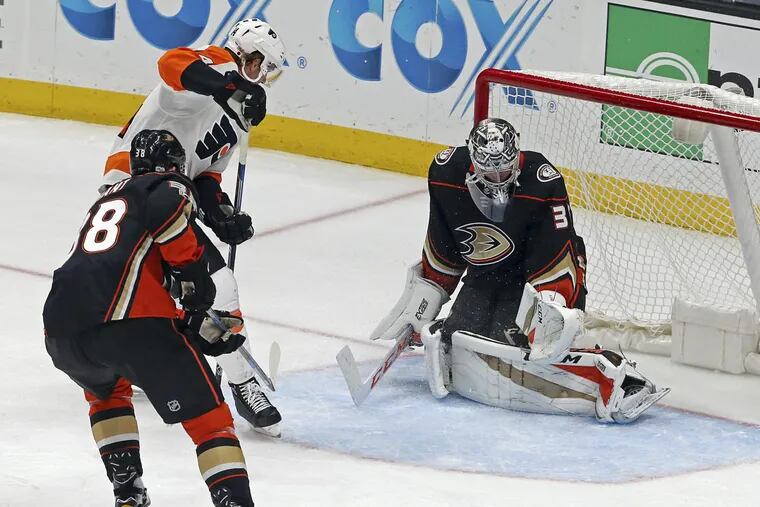 Anaheim Ducks goalie John Gibson (36) just misses getting his glove on a goal by Sean Couturier as Anaheim’s Derek Grant (38) watches in the second period of the Flyers’ 3-2 overtime win.