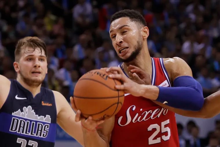 Ben Simmons of Philadelphia 76ers, center, challenges by Luka Doncic of Dallas Mavericks, during the Shenzhen basketball match of the NBA China Games in Shenzhen city, south China's Guangdong province, Monday, Oct. 8, 2018. (AP Photo/Kin Cheung)