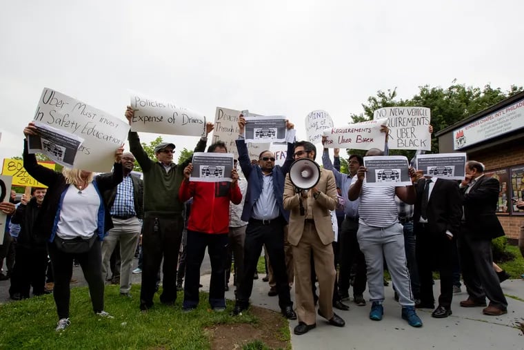 Uber and Lyft drivers rallied in May outside Uber's Southwest Philadelphia hub to speak out against pay cuts and unfair labor conditions. A California gig worker bill could help pave the way for local labor protections.
