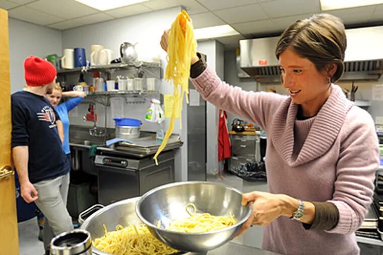 Villanova professor Stephanie Sena prepares spaghetti at a dinner for the men at Old First Reformed United Church of Christ. She leads students working there. (Sharon Gekoski-Kimmel / Staff Photographer)