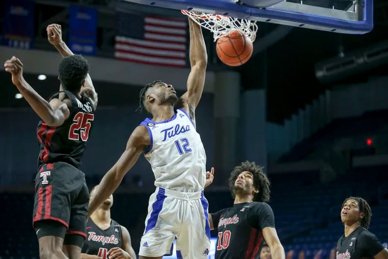 Tulsa center Emmanuel Ugboh (12) throws down a dunk during the Golden Hurricane's win over Temple