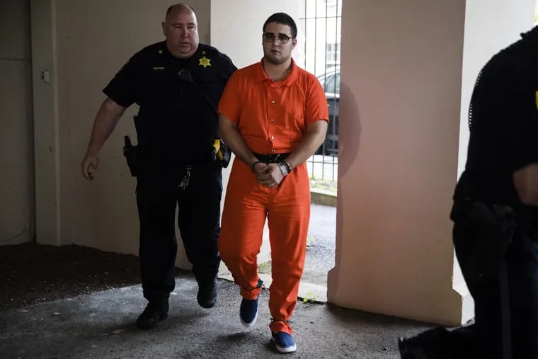 A law enforcement official escorts Cosmo DiNardo to jail in July.