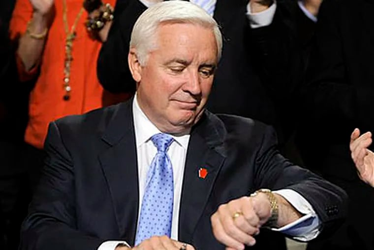 Pennsylvania Gov. Tom Corbett checks his watch following his signing the state budget documents in the rotunda of the capitol last Thursday in Harrisburg. Corbett promised an on-time budget with no new taxes as part of his gubernatorial campaign. He delivered, but at a high price to schools and colleges. (AP Photo / Bradley C Bower)