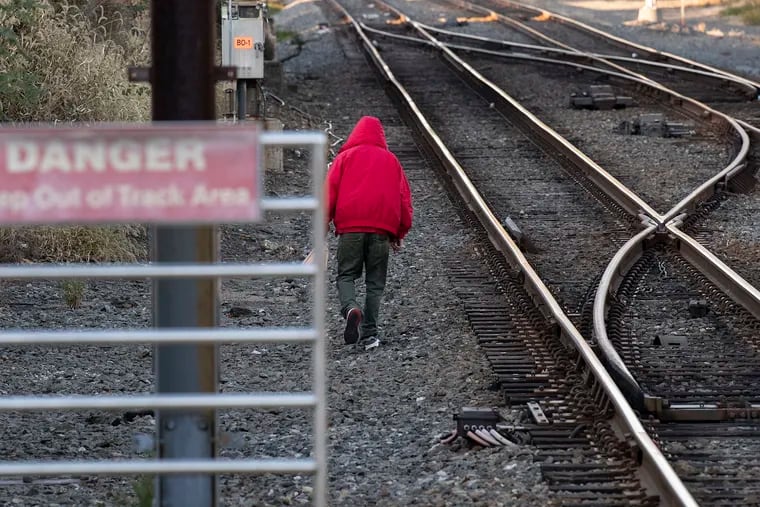An unidentified man walks along the track near the Fern Rock Station in Philadelphia, Pa. Monday, November 6, 2019