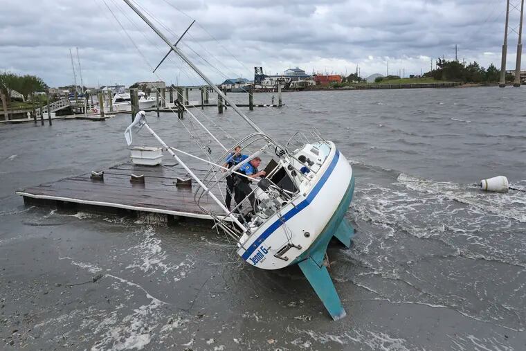 Beaufort Police Officer Curtis Resor, left, and Sgt. Micheal Stepehens check a sailboat for occupants in Beaufort, N.C. after Hurricane Dorian passed the North Carolina coast on Friday, Sept. 6, 2019.