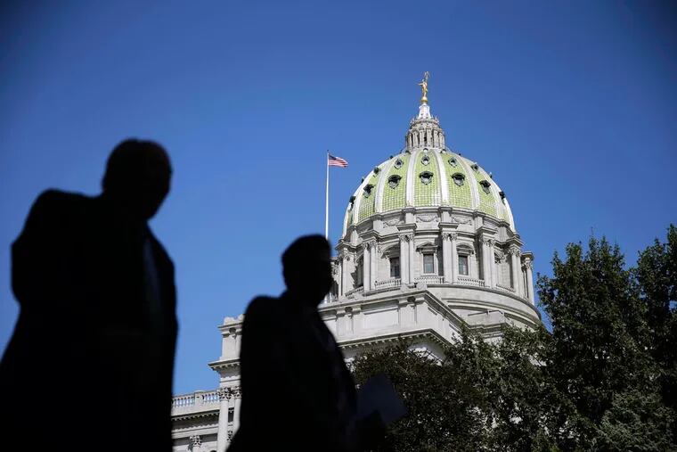 In this Oct. 7, 2015 photo, people walk past the Pennsylvania Capitol building in Harrisburg, Pa.