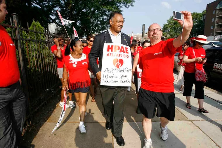 Striking Red Cross worker Lenny Lerro takes a picture of himself with the Rev. Jesse Jackson as they walk the picket line Tuesday morning on Spring Garden Street in Philadelphia.