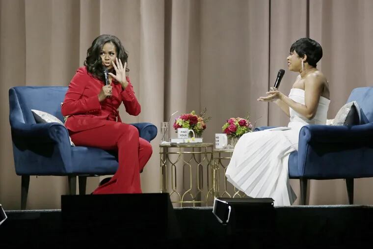 Michelle Obama greets the crowd during her Becoming: An Intimate Conversation with Michelle Obama tour, featuring moderator Phoebe Robinson at the Wells Fargo Center in Phila., Pa. on November 29, 2018.