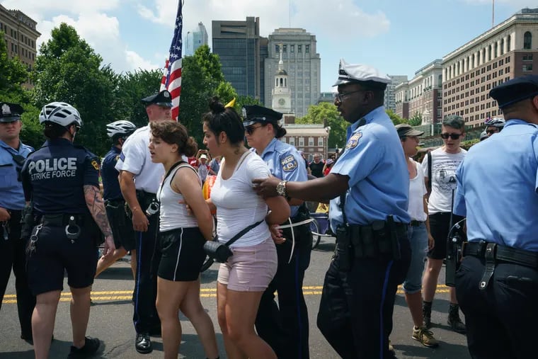Police arrest protesters who interrupted the Independence Day parade with a message demanding the closure of detention camps at the United States-Mexico border.