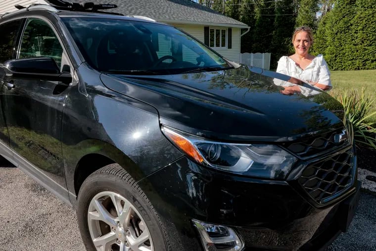 Nadine Hughes stands outside her Phoenixville home with the Chevy Equinox she bought off its lease for $0 in additional fees at a Reading dealer.