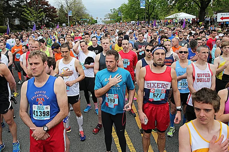 Runners pause during the national anthem. (David Maialetti/Staff Photographer)