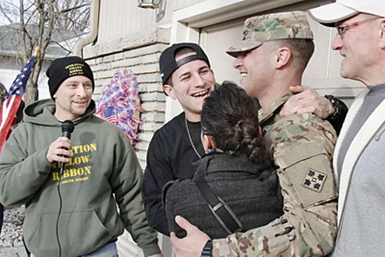 Dave Silver of Operation Yellow Ribbon of South Jersey, who helped organize the welcome home, watches Jared Little hug his older brother, Army Spec. Josh Little. At right are their parents, Rose and Eric Little.