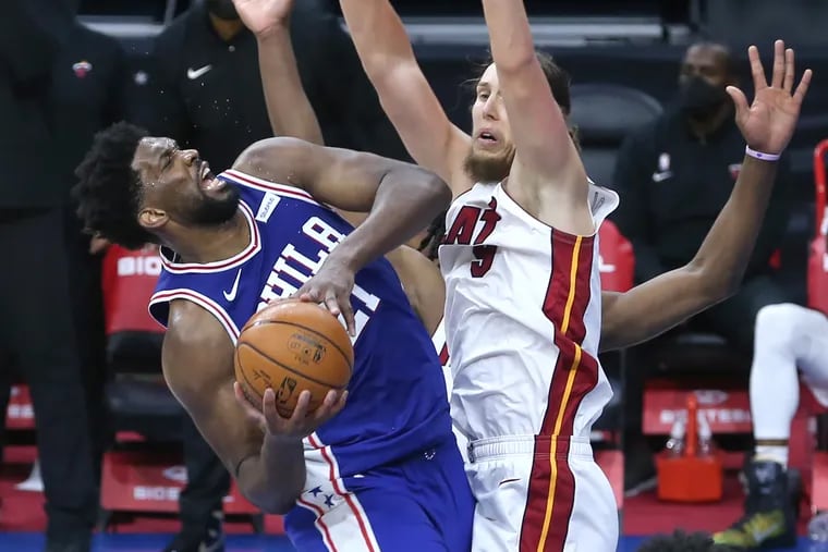 Joel Embiid, left, of the SIxers shoots over Kelly Olynyk of the Heat during overtime of Tuesday's game at the Wells Fargo Cente. Embiid was fouled, and the 3-point play gave the Sixers a 3-point lead.