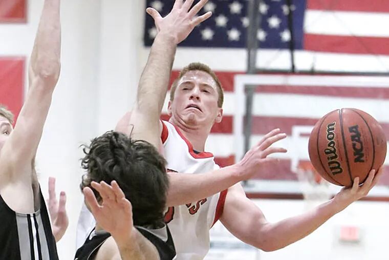 Cherry Hill East's # 3 Jack Silpe shoots around Bishop Eustace's # 12
Connor McLaughlin (left) and # 55 Brandon Cazar in the 4th quarter of
the Bishop Eustace at Cherry Hill East H.S. boys basketball game on
January 8, 2015. Cherry Hill East won the game 36-33.  (Elizabeth Robertson/Staff Photographer)