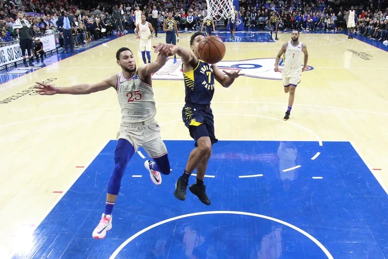 Ben Simmons, left, of the Sixers comes from behind to block a shot by Malcom Brogdon of the Pacers during the 2nd half at the Wells Fargo Center on Nov. 30, 2019.