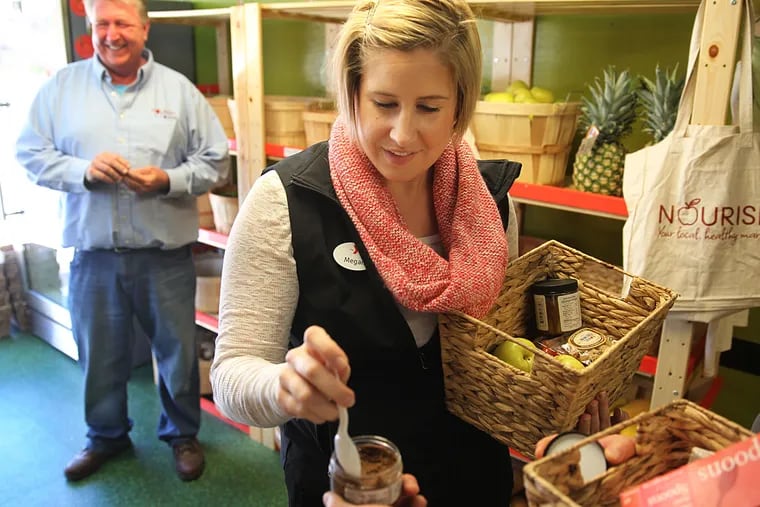 Megan Holloway, a Kennett Square YMCA employee, samples some artisan peanut butter that the Nourish mobil food market is selling.