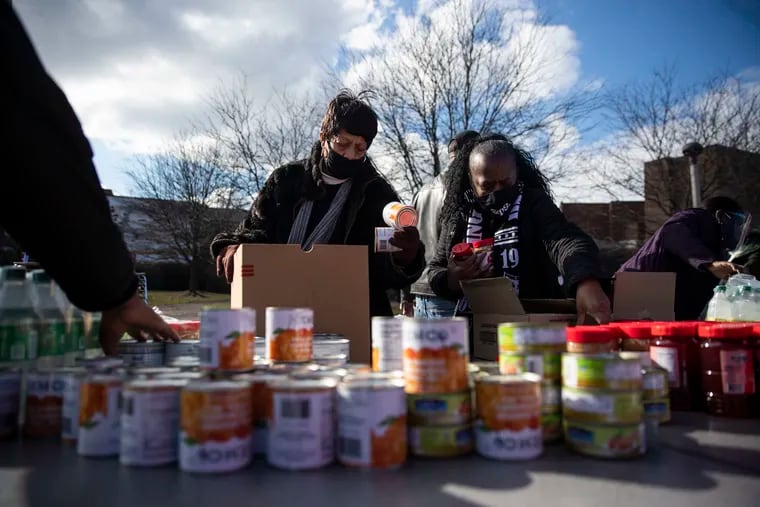 Ellen Paulin, of West Oak Lane, and Rochelle McKelvey, of East Oak Lane, pack food for distribution during the 26th Annual Greater Philadelphia Martin Luther King Day of Service at Martin Luther King High School in Philadelphia, Pa. on Monday, January 18, 2021.