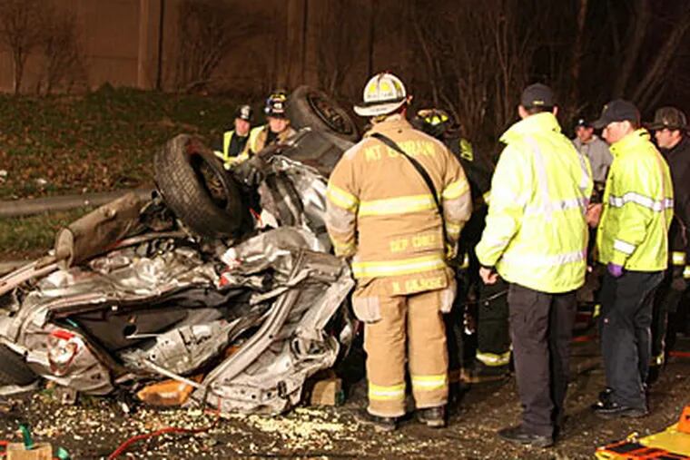 Emergency personnel look over the wreckage from a fiery car crash on I-76 in Camden County. (Steve Skipton / PhillyFireNews.com)