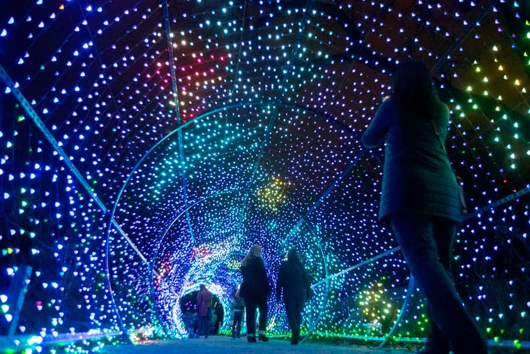 Guests walk through the Philadelphia Zoo's LumiNature holiday light show on Dec. 8, 2022. The event has kept admission prices steady this year despite rising costs.