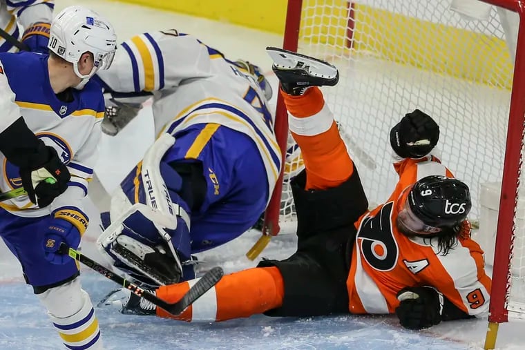 Ivan Provorov lands in the net over Sabres goalie Carter Hutton during the second period of Tuesday night's game. The Sabres thought a penalty should have been called. After the game, the coach suggested the league should look into the play.