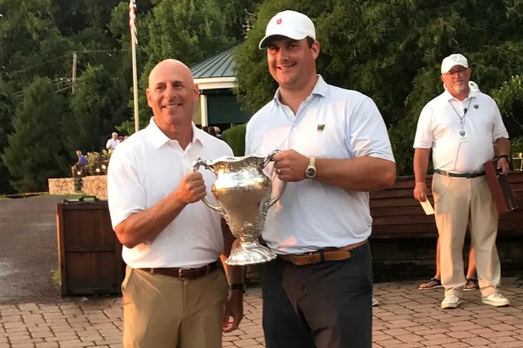 Jeff Osberg (right) accepts the Patterson Cup trophy from Glenn Meyer, chair of the Golf Association of Philadelphia Championship committee.