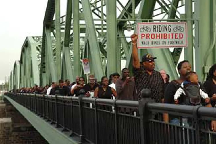 His arm raised, James Evans of Bristol was among the throng that marched across the Lower Trenton Bridge today.