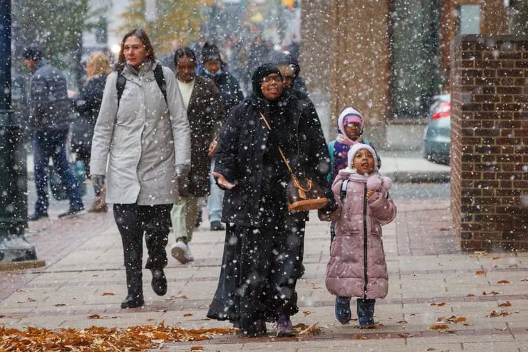Snow falls over Market Street between Sixth and Seventh Streets in Center City on Tuesday.