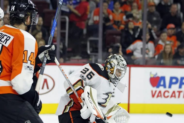 Sean Couturier (left) scored twice against Anaheim goalie John Gibson Tuesday night during an otherwise dismal 6-2 loss for the Flyers. (AP Photo/Tom Mihalek) .