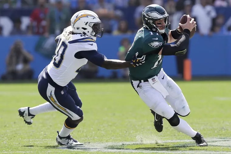 Eagles quarterback Carson Wentz runs with the football past Los Angeles Chargers defensive end Chris McCain during the first-quarter.