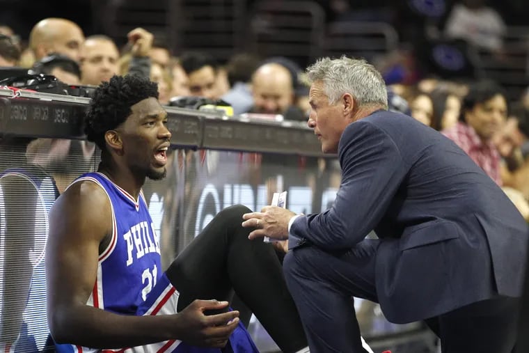Joel Embid, left, of the Sixers and Head Coach Brett Brown talk on the sidelines before Emdid went back into the game late in the 4th quarter against Oklahoma City Thunder on Oct. 26, 2016. CHARLES FOX / Staff Photographer