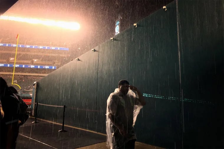 Security guards leave the field as fans are asked to seek shelter during a thunderstorm before the Eagles – Falcons game in September.