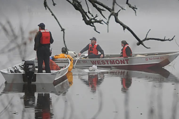 Rescue crews work at the scene of a fatal accident in Collingswood. A Rutgers-Camden student drove into Newton Lake and was found dead on Wednesday morning. (Curt Hudson / For The Inquirer)