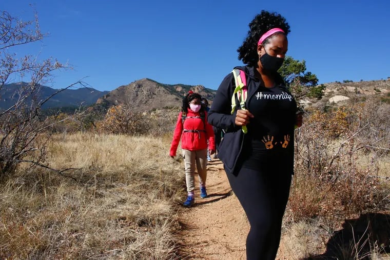 Jessica Newton, right, and her 14-year-old daughter, Joy Eloi, hike through Bear Creek Regional Park in Colorado Springs, Colorado, on Oct. 24, 2020. Newton formed an adventure group to encourage other Black women to enjoy the outdoors and it now has chapters across the U.S. and Canada. (Kevin Mohatt/Kaiser Health News/TNS)