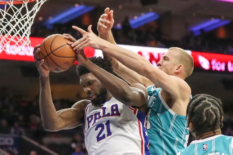 Sixers center Joel Embiid (21) grabs the rebound over Charlotte Hornets center Mason Plumlee (24) in the third quarter of a game at the Wells Fargo Center in Philadelphia on Saturday.