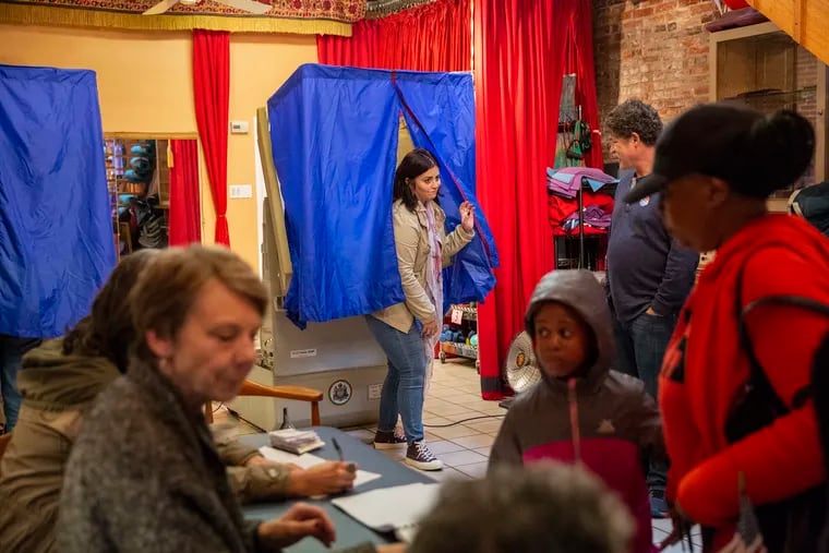 Mayra Madera, center, exits the voting booth inside Studio 1831, a yoga studio in Philadelphia in November 2018.