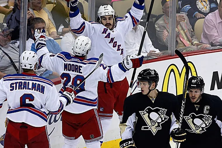 The Rangers' Brian Boyle celebrates his goal with teammates Anton Stralman and Dominic Moore as the Penguins' Sidney Crosby and Olli Maatta skate back to their bench. (AP)