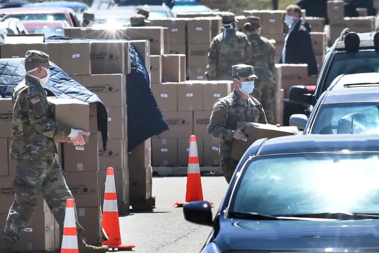 Members of the 128th Brigade Support Battalion of the Pennsylvania Army National Guard work loading boxes of food into cars at a distribution for the Greater Pittsburgh Community Food Bank, Monday, April 20, 2020, in Duquesne, Pa. The food bank has seen a sharp increase in need since statewide shutdowns of nonessential businesses in the COVID-19 pandemic. (Darrell Sapp/Pittsburgh Post-Gazette via AP)
