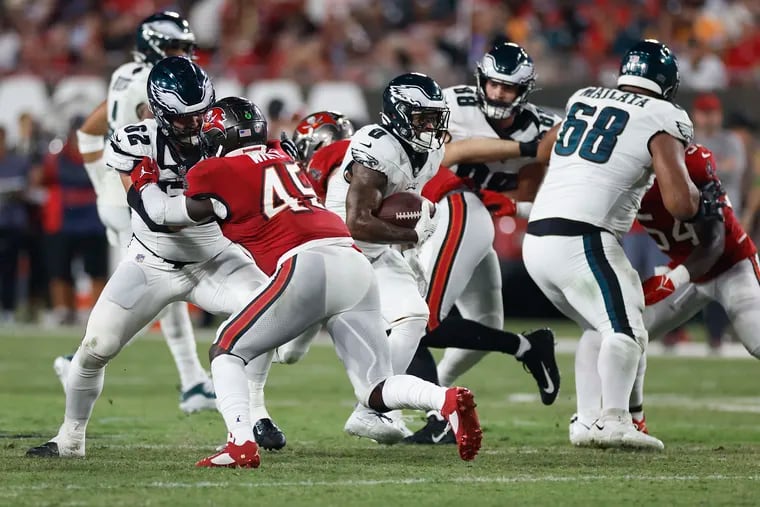 Eagles running back D'Andre Swift finds an opening as center Jason Kelce (left) blocks Tampa Bay's Devin White on Monday.