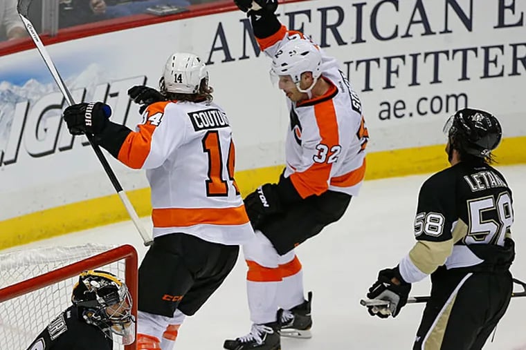 Mark Streit (32) celebrates his game-winning overtime goal past Pittsburgh Penguins goalie Marc-Andre Fleury (29) with teammate Sean Couturier (14) during an NHL hockey game in Pittsburgh, Saturday, April 12, 2014. The Flyers won 4-3. (Gene J. Puskar/AP)