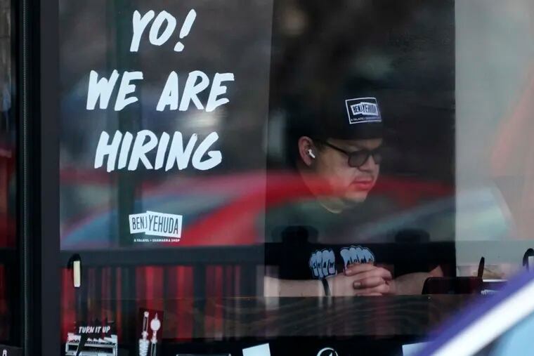 A hiring sign is displayed at a restaurant in Schaumburg, Ill.