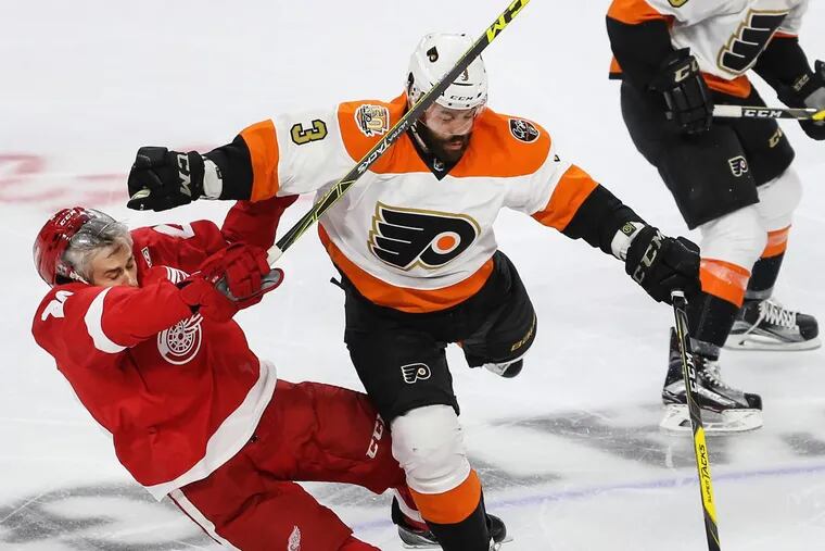 Radko Gudas, checking Detroit’s Drew Miller in a game last season, isn’t eligible to return to the Flyers’ lineup until Dec. 12.