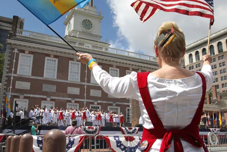 Brenda Exon, the Philly Pride Lady, waves flags in front of Independence Hall during the Celebration of Freedom Ceremony held there on July 4, 2013.   ( CHARLES FOX / Staff Photographer )
