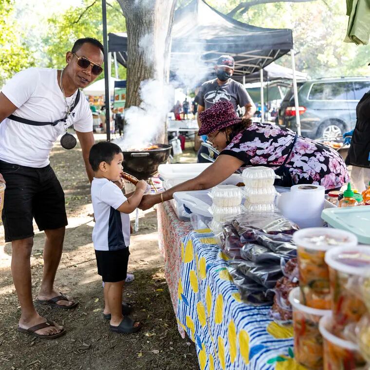 Jimmy Phy, of South Philadelphia, with his grandson Eli Phy, 2, visiting vendors to eat some food and enjoy the day at the Southeast Asian Market at FDR Park in Philadelphia, Pa.