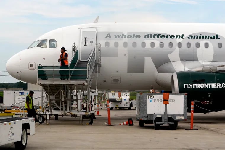 Ground crew members prepare a Frontier Airlines jetliner for a flight to St. Augustine, Fla.