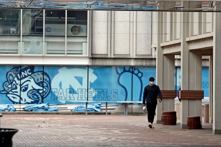 A pedestrian walks through campus at the University of North Carolina in Chapel Hill, N.C. in 2020. A federal judge has ruled that North Carolina’s flagship public university may continue to consider race as a factor in its undergraduate admissions. The ruling goes against plaintiffs who argued that race-based admissions put white and Asian students at a disadvantage.
