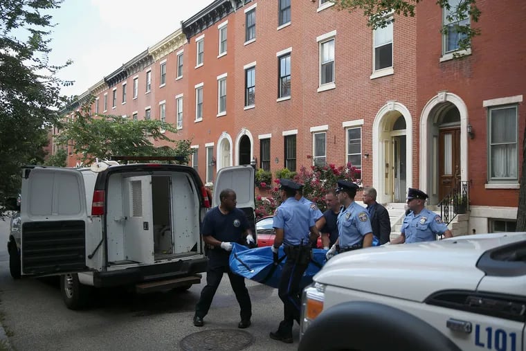 Philadelphia Police remove a body that was found wrapped in a tarpaulin from an apartment in the 1900 block of Mount Vernon Street in the Spring Garden section of Philadelphia on Wednesday, July 18, 2018.