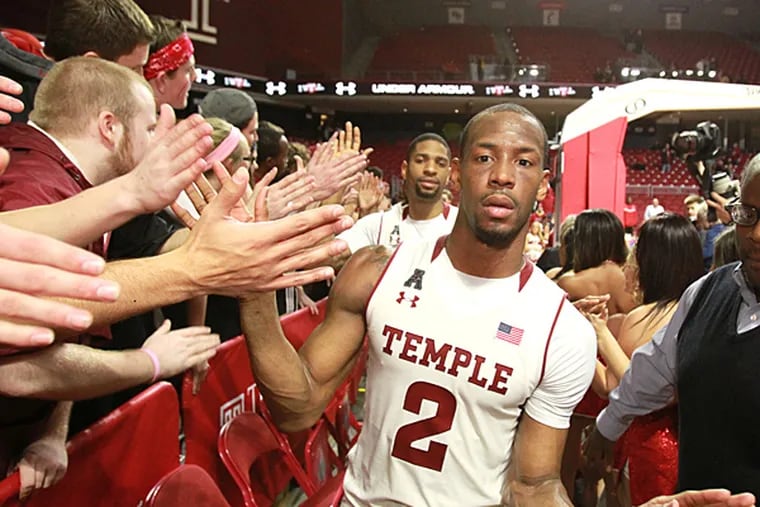 Temple players Jesse Morgan, left, and Will Cummings make their way through a gauntlet of students on March 25, 2015, at the Liacouras Center after defeating Louisiana Tech 77-59 to advance to the NIT semi-finals in New York City. (Charles Fox/Staff Photographer)