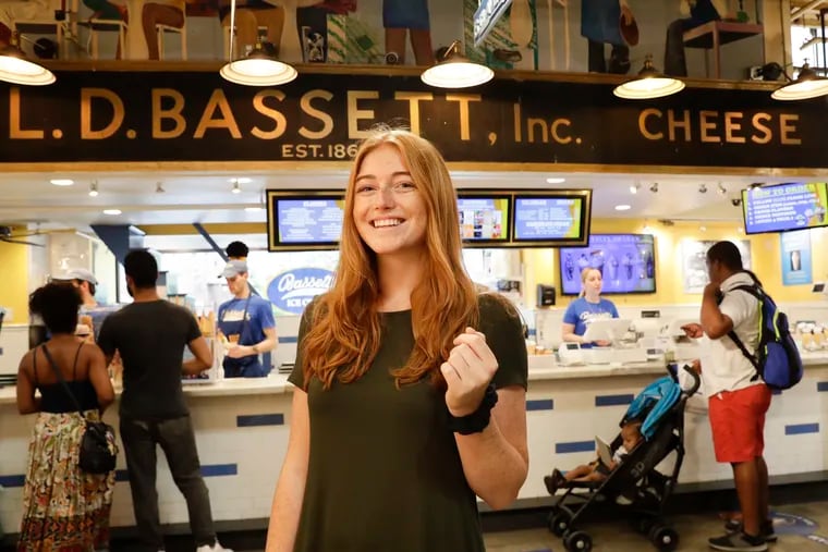 Recent Temple graduate Claire Dabney stands near the Bassetts Ice Cream shop at the Reading Terminal Market on Monday, July 15, 2019.  The Lancaster native is staying in Philly and Reading Terminal Market is one of her favorite places.