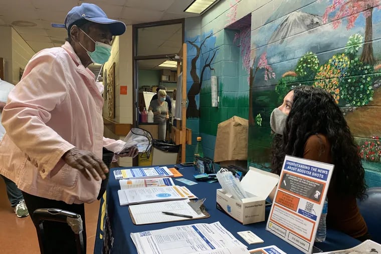 Shirley Townes talked with Philadelphia Department of Public Health staffer Jennyfer Osuna about COVID-19 vaccine booster shots at the South Philadelphia Older Adult Center Friday, Oct. 15.