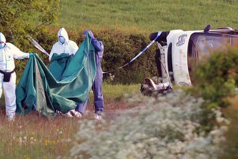 Forensic officers examine a car containing a body near Seascale after Derrick Bird drove through England's scenic Lake District on Wednesday shooting people, killing 12 and wounding 25.